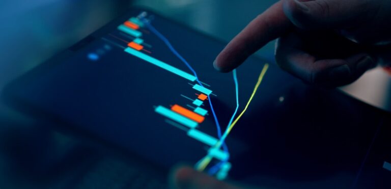 Fingers interacting with a stock market graph on a tablet.
