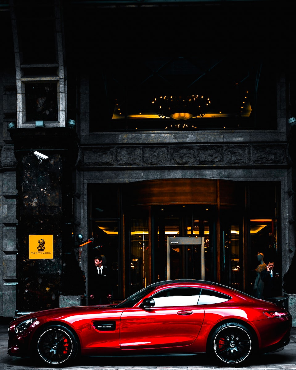 Foto von Serge Kutuzov red coupe parked in front of black and gray building during daytime