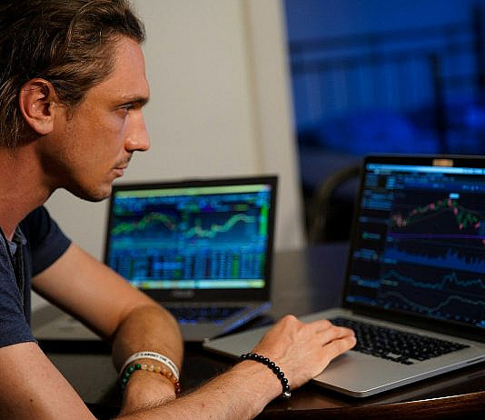 Aktien: Grundlagen, Chancen, Risiken & Praxis man sitting in front of the MacBook Pro