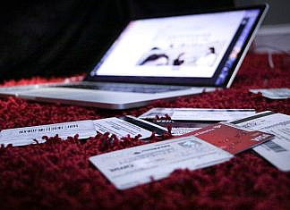 Kreditkarte online beantragen white printer paper on red textile