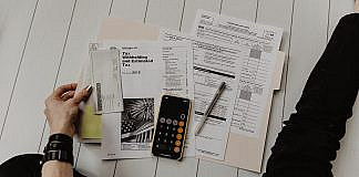 Steuern & Regeln: Grundlagen, Chancen, Risiken & Praxis person holding paper near pen and calculator