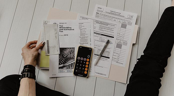 Steuern & Regeln: Grundlagen, Chancen, Risiken & Praxis person holding paper near pen and calculator